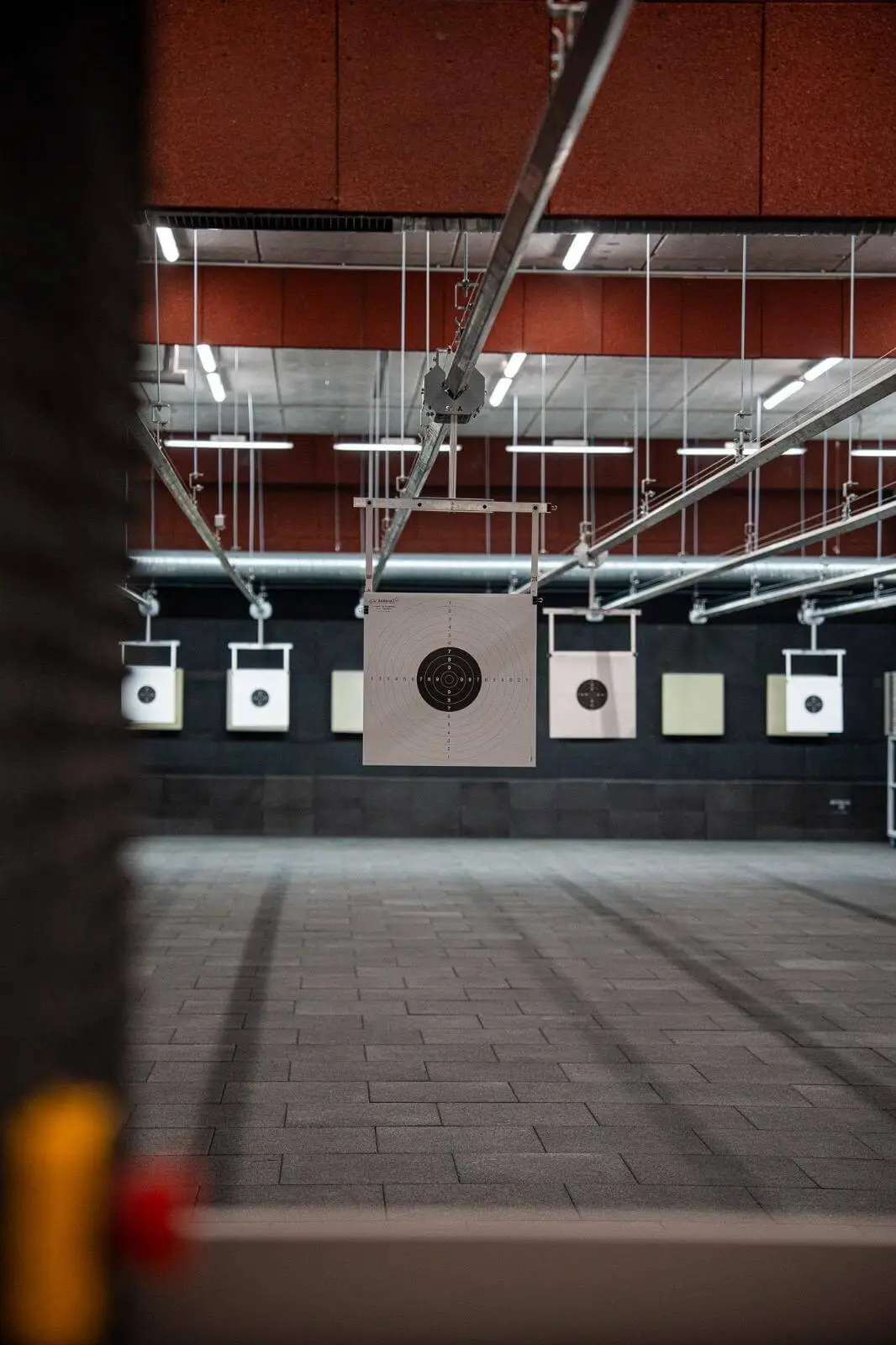 Vue d'ensemble du stand de tir de L'Arsenal Tir Concept avec cibles suspendues